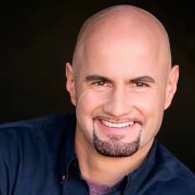 Smiling bald man with a dark goatee